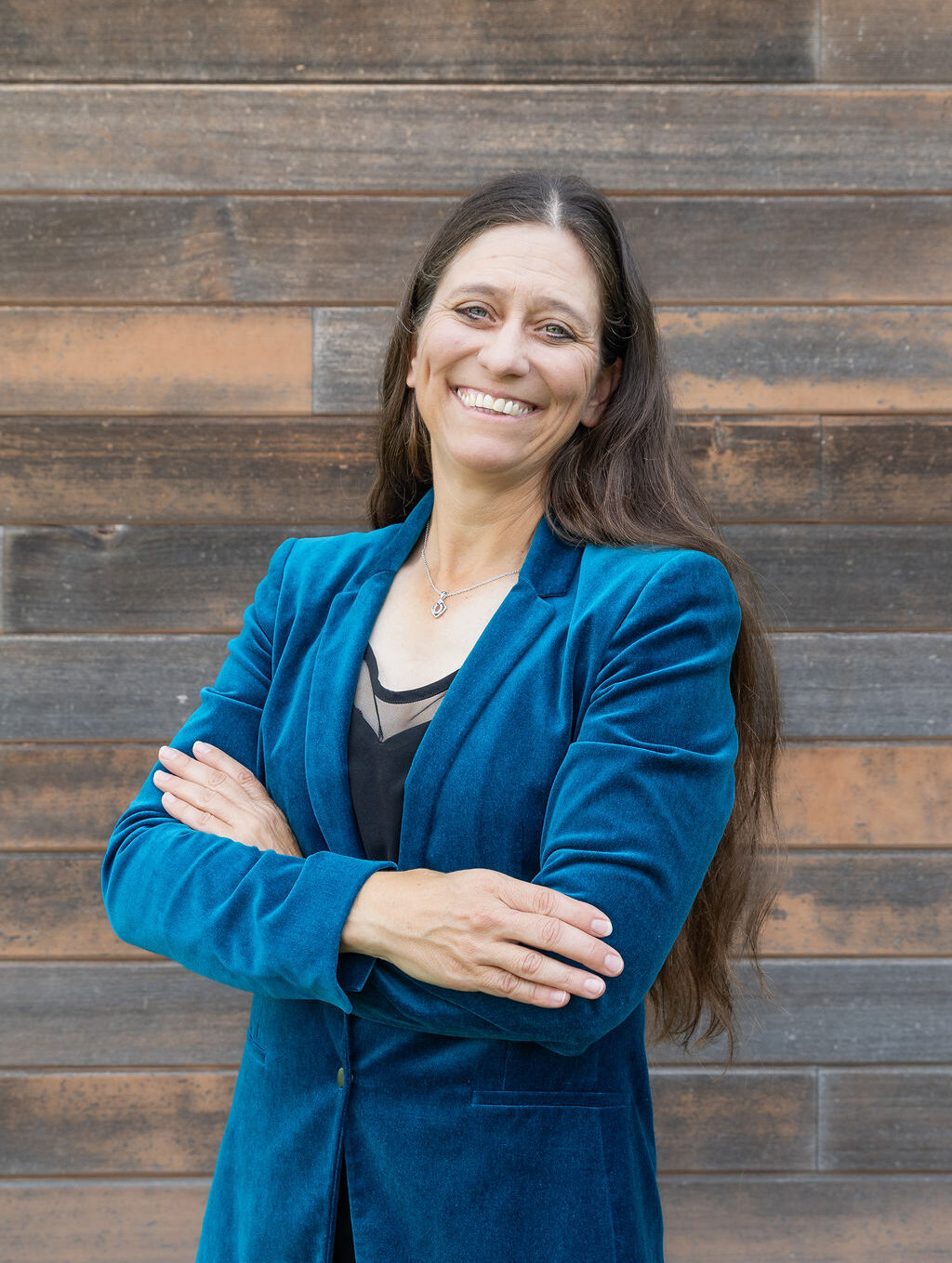 a woman standing in front of a wooden wall