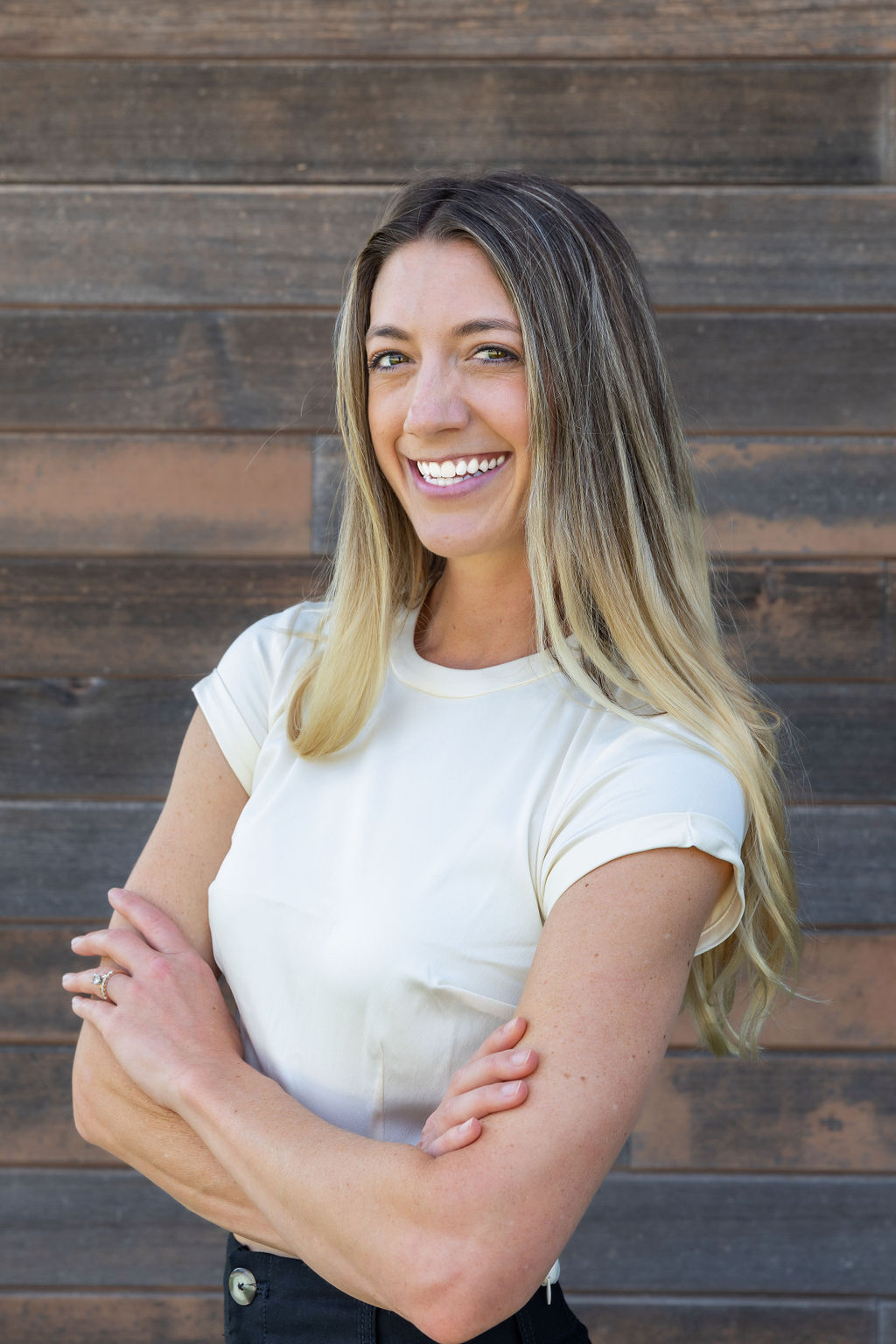 a woman standing in front of a wooden wall