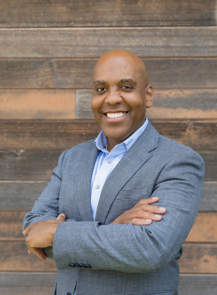 a man standing in front of a wooden wall