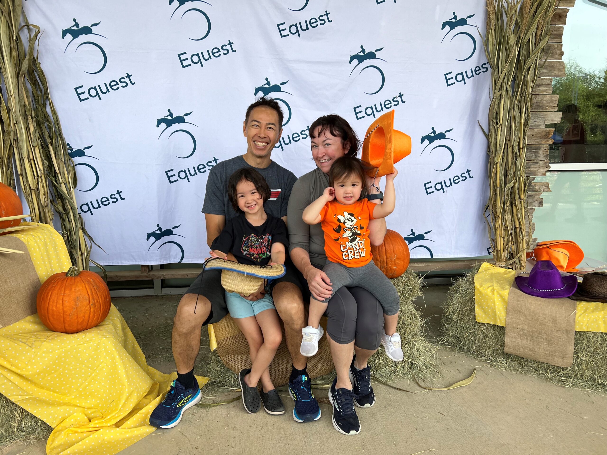 A family poses for a picture in front of a backdrop