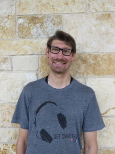 man standing in front of a stone wall