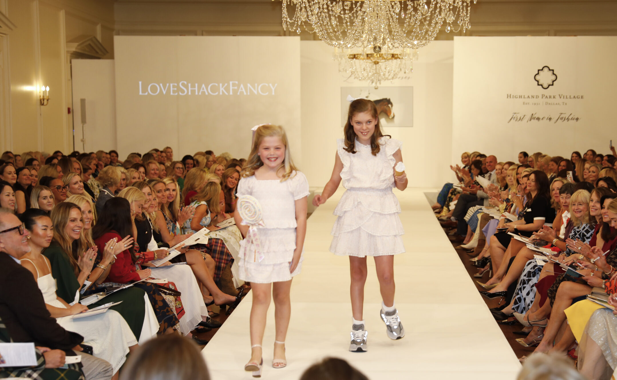 wo young girls walking down the runway at a fashion show