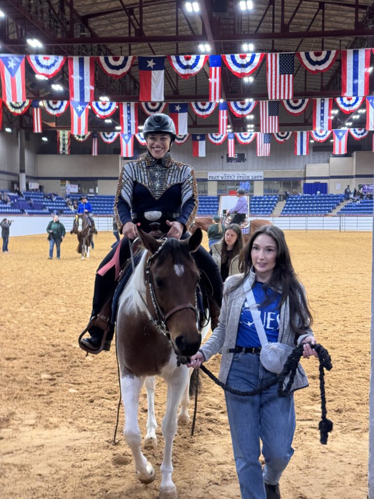 woman is walking a horse in an arena