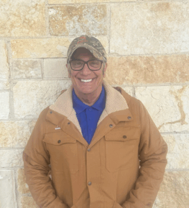 man standing in front of a stone wall