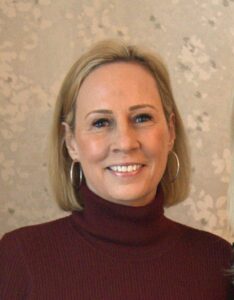 woman in a red turtle neck sweater holding a cell phone