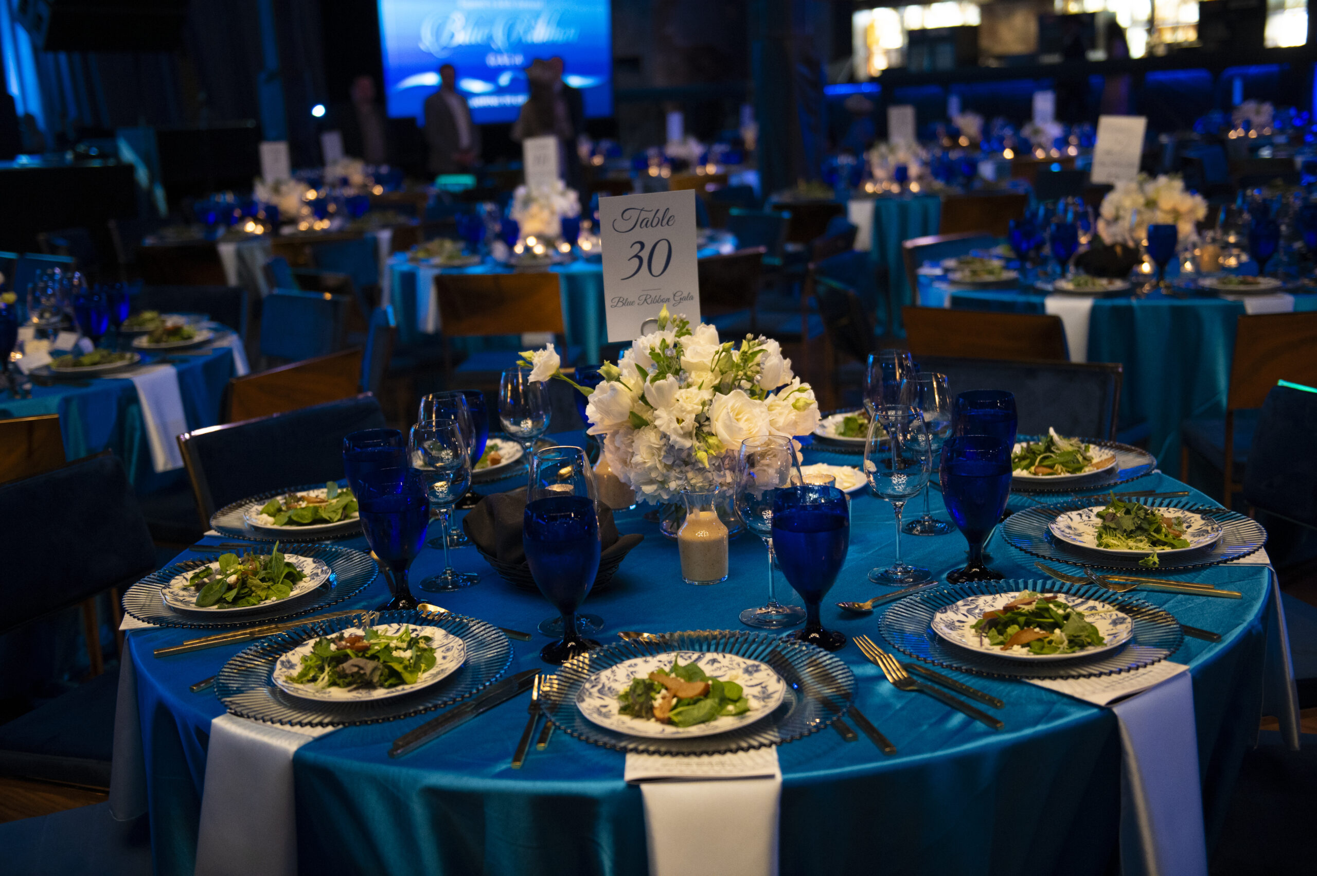 table set for a formal dinner with blue linens