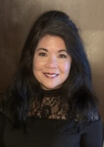 woman in a black dress smiling at the camera