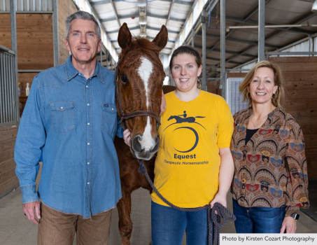 a man and two women standing next to a horse